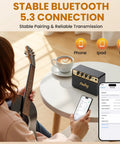 Compact 10W Bluetooth Guitar Amp For Practice With Dual Clean And Distortion Channels on table next to smartphone