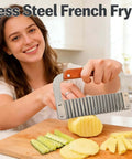 French fry slicer with stainless steel blade and wooden handle; potatoes on a cutting board in a kitchen.