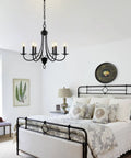 Black 6 Light Farmhouse Chandelier for Dining Room 22.4 Inch with E12 Base hanging in a cozy rustic bedroom