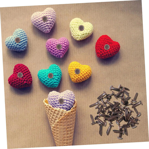 Colorful knitted hearts with Fifty Piece Double Foot Spikes Metal Brads For Scrapbooking And DIY Crafts Durable Paper Fasteners scattered.