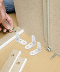 Person assembling furniture with Stainless Steel Right Angle Corner Brackets For Wood 12 Pack L Shape Braces For Table Legs And Beds
