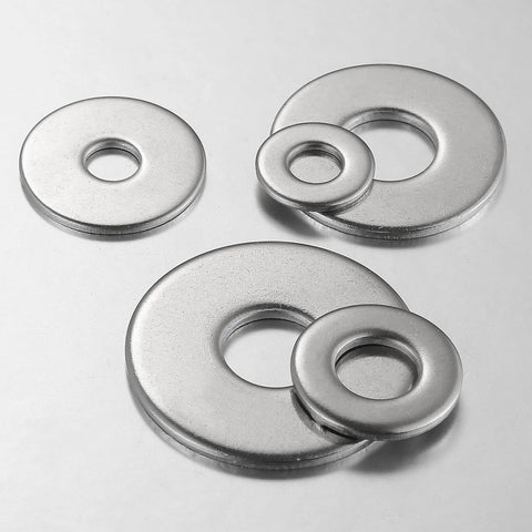 Top-down view of four stainless steel flat washers with centered holes and varying outer diameters.