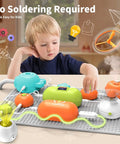 Child exploring STEM Electronics Kit For Kids With 31 Circuit Parts And 300 Plus Projects No Soldering Needed on grey mat