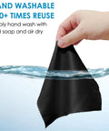 Front view of black microfiber cleaning cloth, 7 x 6 inches, being wrung by hand over water.