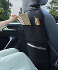 View of waterproof leather back seat protector with three storage pockets, used as an anti-kick mat for kids and pets in a car.