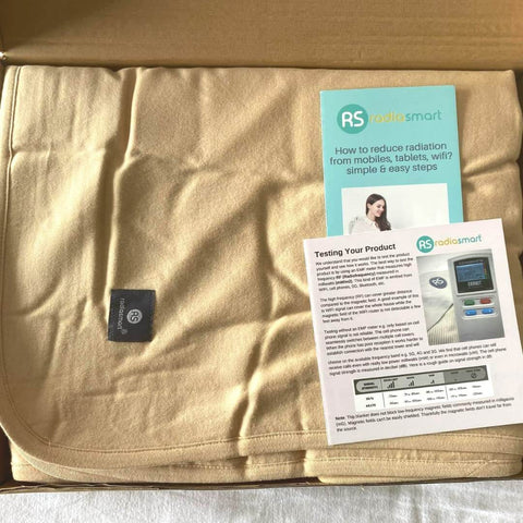 EMF Shielding Large Bed Blanket Made From Organic Cotton With Silver Lining, 57 by 78 inches, shown in packaging with instruction leaflets