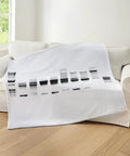 DNA Gel Black And White Throw Blanket Plush Fleece 60 By 50 Inches displayed on a white couch in cozy living room