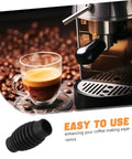 Espresso machine with steam wand and black rubber insulation sleeve beside a coffee cup on a bean background