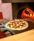 Turning Pizza Peel With 8 Inch Aluminum Round Paddle For Outdoor Ovens 23 Point 6 Inch Total Length nonstick tool in use