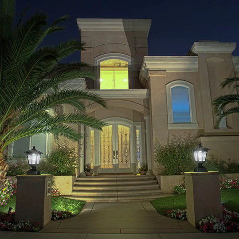 Night view of house entrance with Outdoor Solar Powered Post Cap Lights For 4x4 Wood Posts, Classic Lantern Style on pillars.