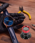 Pro Grade Metal Loupe Magnifier for watch repair next to watch and tools on wooden table