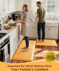 Two people using Anti Fatigue Kitchen Mat Cushioned 0.75 Inch Thick Standing Pad For Kitchen Office And Sink 20 By 32 Inches Waterproof Ergonomic Comfort Non Slip Bottom Bright Orange Easy To Clean in a kitchen.