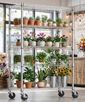 Tough As Nails Five Tier Chrome Wire Shelving Rack With Locking Casters And Nsf Certification For Kitchen Garage Or Home Office Storage Up To Three Hundred Fifty Pounds Per Shelf filled with various potted plants.