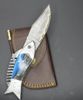 Fish Style Folding Knife With Ladder Pattern Damascus Blade And Blue Resin Handle on leather sheath