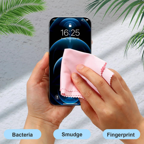 Front view of hand wiping smartphone screen with pink microfiber cleaning cloth.