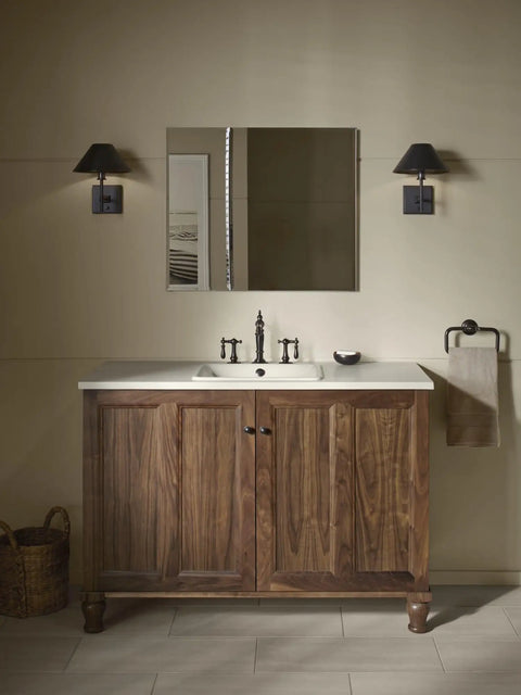 Bathroom medicine cabinet with mirror above wooden vanity, featuring double beveled doors and mirrored interior for storage.
