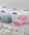 Heavy Duty Clear Storage Bins 2 Pack With Tight Blue Latches showcasing neatly folded clothes on a closet shelf.