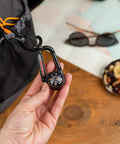 Hand holding Ball Compass And Thermometer Carabiner For Hiking And Camping Clip On Grab And Go Gear For Backpacks Parkas Or Jackets