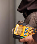 Person using label maker printing Rhino Industrial Flexible Nylon Labels Three Quarters Inch By Eleven Point Five Foot Black Print On White Tape Built Tough For On The Job Moisture And Temperature Resistant Adhesive That Will Not Curl Or Peel Ideal For Harsh Environments