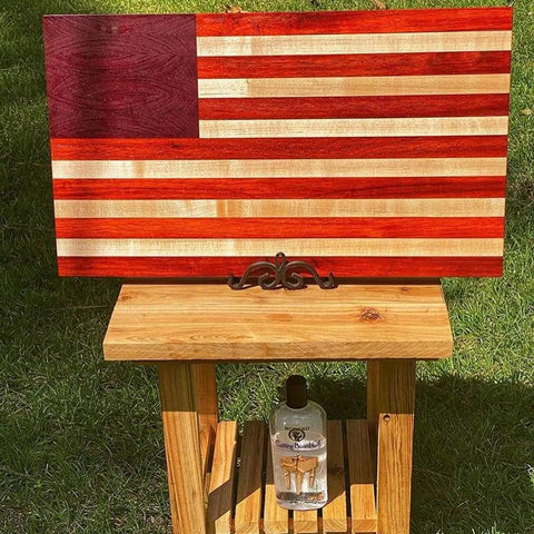 American flag design cutting board on stand, with Heavy-Duty Go-To Butcher Block Conditioner And Cutting Board Oil, 12 oz bottle below.