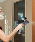 Person using Heavy Duty PU Foam Spray Gun Featuring Slick Pneumatic Trigger And Self Cleaning Design for wall cavity foaming.