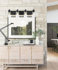Four Light Black Wall Sconce Vanity Light With Seedy Glass Shades 28 Inch mounted above a sideboard against stone wall