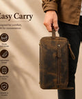 Premium Travel Wash Bag For Men And Women Rock Solid Buffalo Leather Shaving Kit Pouch held by a person, showcasing side handle and zipper.