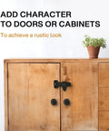 Vintage Style Black Wrought Iron Flip Latch Hardware Kit For Double Doors on wooden cabinet with plant on top.