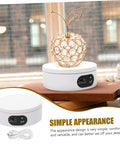 Rotatable Jewelry Display Stand With Electric Motorized Turntable Skid Base showcasing a golden apple design on a white base.