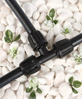 Half Inch All In One Pro Grade Irrigation Fittings Kit with 16mm tubing tee connector on white stones with green foliage