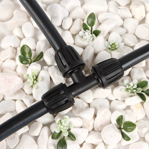 Half Inch All In One Pro Grade Irrigation Fittings Kit with 16mm tubing tee connector on white stones with green foliage