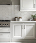 Modern kitchen with hexagonal tile backsplash, stainless steel stove, and white cabinets featuring 8 Pack Brushed Nickel Cabinet Handles 5 Inch Square Drawer Pulls Stainless Steel With 128mm Hole Centers For Kitchen Cabinets And Drawer Fronts Easy Installation And Durable Hardware.