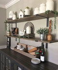 Modern kitchen with open shelves supported by Beefy Heavy Duty Shelf Brackets Set 4 Pack Premium Construction Grade Quarter Inch Thick Steel Matte Black Finish L Bracket With Lip For Modern Farmhouse Open Shelving Hardware Included 11.25 By 6 Inches. Decor items include white jars and plants.