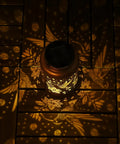 Hummingbird Solar Lanterns For Outdoor Garden Decor projecting warm hummingbird pattern on wooden surface, gold copper finish