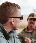 Man wearing Ion Pro 2 Bluetooth Rechargeable OTC Hearing Aids with App Control, UV Cleaning, and Enhanced Streaming Audio outdoors.