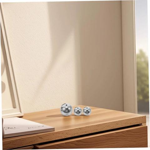 Steel and plastic balls on a wooden surface for 5-Piece Pendulum Ball Assembly Kit For Physics Education And Mechanics Learning.
