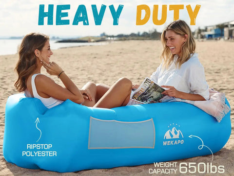 Two women relaxing on blue Inflatable Couch Air Lounger Chair For Camping And Beach Trips Portable Blow Up Sofa at the beach.