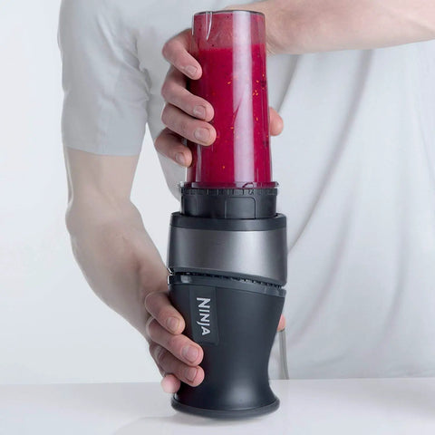 Man using Ninja Blender Cups 16 Ounce Single Serve Replacement Cups With Two Sip Lids For BL770 BL780 BL660 Professional Blenders