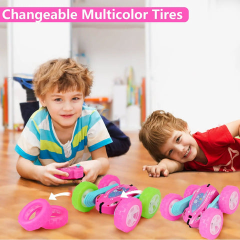 Two children playing with a Pink Remote Control Car For Girls That Flips 360 Degrees, featuring changeable multicolor tires.