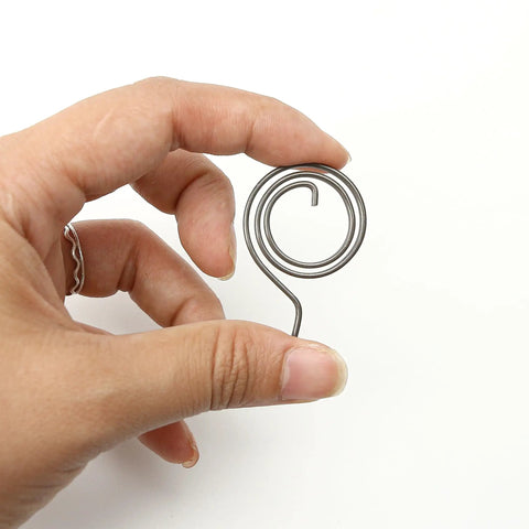 Hand holding 8 Piece Door Handle Spring Set For Knob And Lever Latch Replacement DIY Friendly Internal Coil Repair Spindle Lock Torsion Return Spring 16 Gauge Wire Includes 8 Sizes Check Size Carefully Before Ordering coil spring