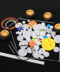 78 Piece Plastic Gear Kit For Motors And Robots with axles, reduction gears, racks, and tires on black background