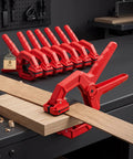Eight Pack Edge Band Spring Clamps For Edge Banding And Woodworking Adjustable Clips on wooden board in workshop.