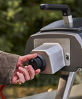 Close-up of gas burner attachment for Karu 12 2 12G pizza oven, showing regulator and hose setup for propane conversion.