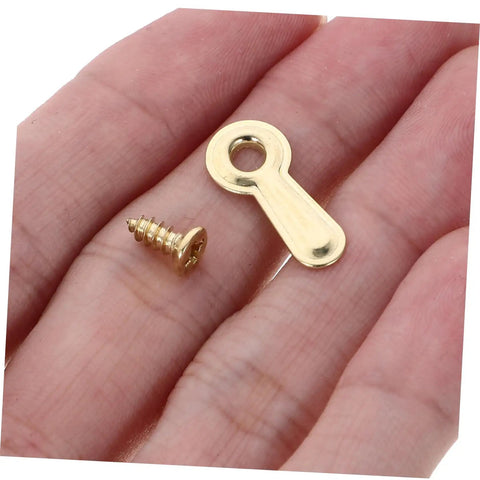 Heavy Duty Iron Picture Frame Backing Clips Featuring Quick Turn Button Fasteners And All Included Mounting Screws For Hanging Wall Photos Artwork Crafts Straight Up No Sweat, close-up of gold screw and clip in hand.