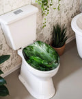 Round Tropical Rainforest Stream Dense Green Jungle Misty Toilet Seat on a white toilet in a bathroom with plants.