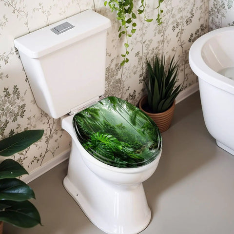 Round Tropical Rainforest Stream Dense Green Jungle Misty Toilet Seat on a white toilet in a bathroom with plants.