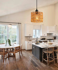 Total Vibe Hand Woven Rattan Pendant Light illuminating a modern kitchen with white cabinets and dining table.