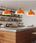 MIELPOXS Modern Dome Pendant Light Iron Metal Hanging Ceiling Fixture with orange dome shades hanging above a bar area.