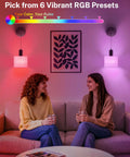 Two women sitting under Cordless Battery Operated Wall Sconces Set Of 2 With Remote Control, showing vibrant RGB lighting effects.