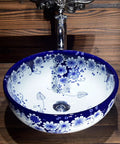 USZWBY Vessel Sinks Blue and White Porcelain Bathroom Basin Sink round ceramic sink with floral design on a wooden countertop.